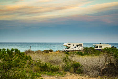 Camper, recreational vehicles on mediterranean coast in Spain. Camping on nature beach. Holidays and travel in motor home.の写真素材