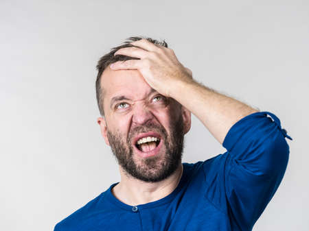 Adult bearded man face palming his hand on forehead. Guy did something stupid.の写真素材