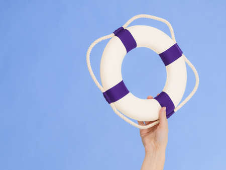 Hand showing white blue life buoy ring lifebelt with rope. Safety equipment. Accident prevention and water rescue.の写真素材
