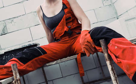 Woman wearing workwear working on construction site. Partially built new home early stage. Industry.の写真素材