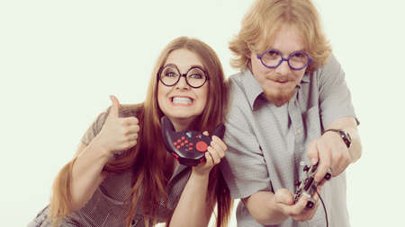 Very emotional couple enjoying leisure time by playing video games together. Studio shot