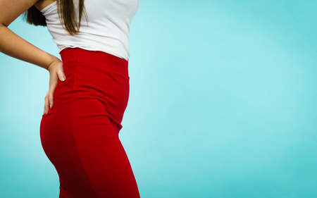 Unrecognizable woman with curvy body having fashionable outfit, red skirt. Fashion and clothing concept, on blueの写真素材