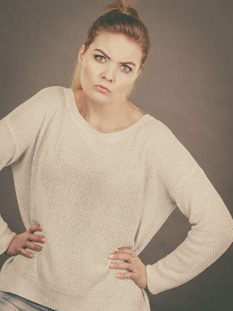 Confused young blonde woman looking suspicious. Confusion face expressions concept. Studio shot on...