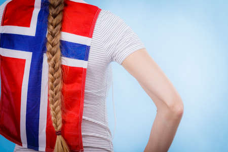 Blonde girl braid hair with norwegian flag on her back. Scandinavian people.の写真素材