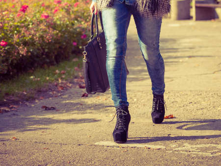 Autumnal fashion of women. Fashionable girl wearing trendy clothes walking in park. Part body of model outdoors.の写真素材