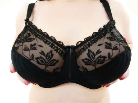Close up female huge boobs breast in lingerie, wide angle view. Plus size woman wearing black lace soft bra. Bosom, brafitting and underwear concept.の写真素材