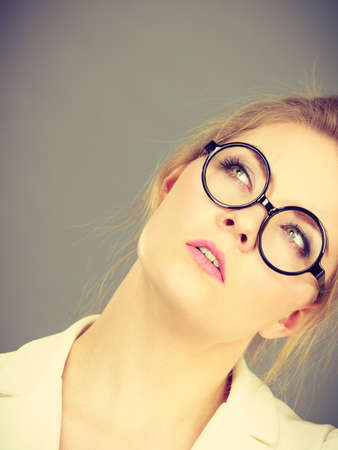 Business woman wearing white jacket and eyeglasses intensive thinking finding great problem solution.の写真素材