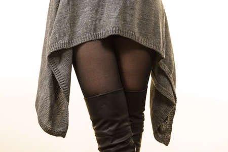 Unrecognizable woman wearing gray long top sweater tunic, black tights. Stylish, autumnal outfit.の写真素材