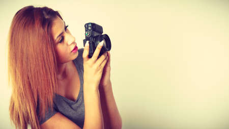 Hobby, creative passion concept. Young brunette woman taking pictures with digital camera