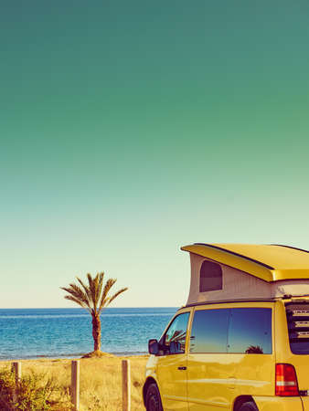 Camper van with tent on roof camping on mediterranean coast with palm trees in Spain. Percheles Beach. Holidays and travel in motor home.の写真素材