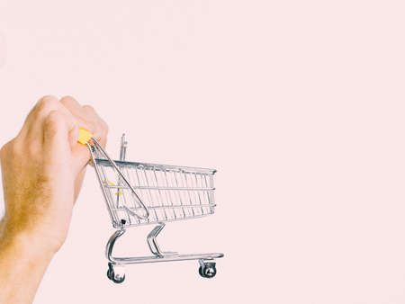 Male hands holding empty shopping basket cart, toned image. Seasonal sales, boxing day concept.の写真素材