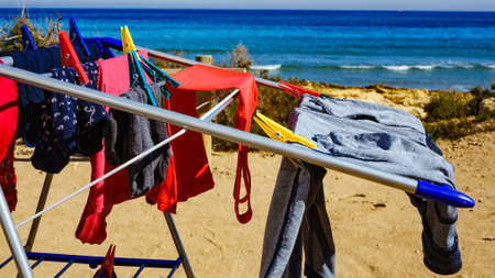 Camping on beach, adventure concept. Clothes hanging to dry on laundry line outdoor against sea.の写真素材