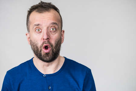 Shocked amazed beared adult guy having astonished full of disbelieve face expression.の写真素材