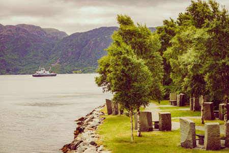 Picnic site rest stop area stone chairs and table on norwegian fjord shore, Tourist route Ryfylke....