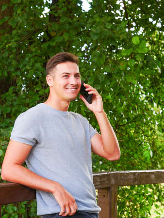Technology and communication. Man using mobile phone talking on smartphone outdoor in park