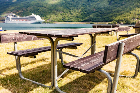 Rest area with table benches and cruise ship on fjord in distance, norwegian tourist destination Flam. Travel destination.の写真素材