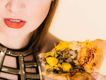 Young woman eating hot fresh pizza slice. Delicious fast food meal. People, italian cuisine concept.の写真素材