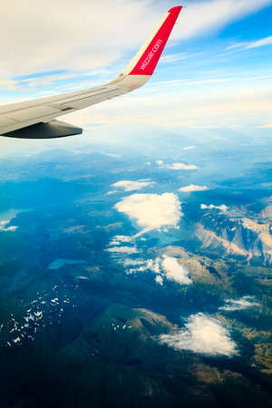 BERGEN, NORWAY - JULY 27, 2014: Wizzair airline wing. Sky view from the airplane window. W!zz Air is Hungarian low cost airline founded in 2003.のeditorial素材