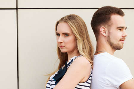 Young couple not talking to each other, standing back to back after argument quarrel. Disagreement...