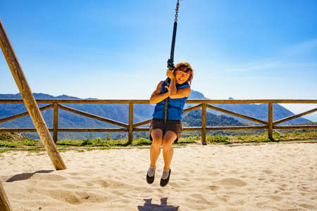 Adult freedom woman tourist having fun on zipline, descend on rope, cable aerial ropeslide. Mountains rest place in Spain Alicante region. Costa Blanca holiday.の写真素材
