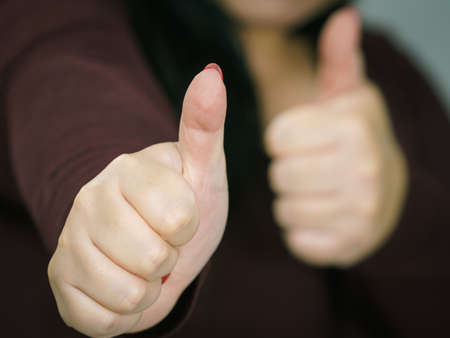 Adult happy big woman making thumb up gesture showing cool sign, on grey. Satisfaction success...