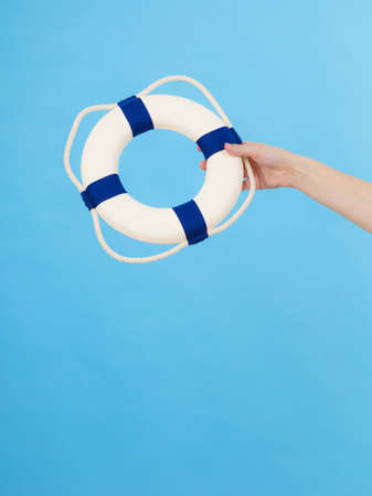 Hand showing white blue life buoy ring lifebelt with rope. Safety equipment. Accident prevention and water rescue.の写真素材