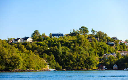 BERGEN, NORWAY - JULY 22, 2014: Norwegian houses on fjord shore near Bergenの写真素材