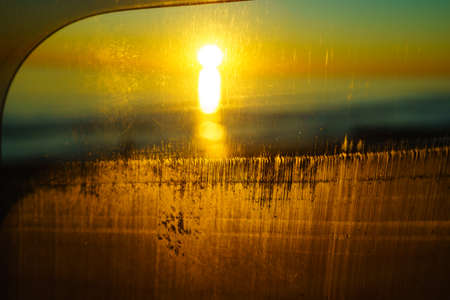 Sunrise or sunset over sea surface. View from camper car window