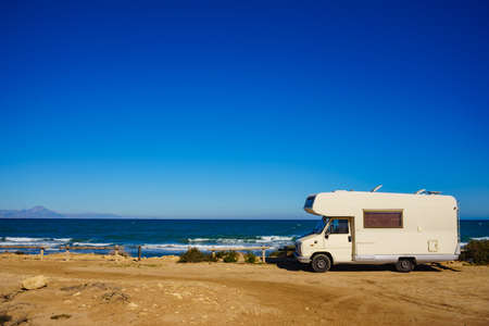 Camper, recreational vehicle on mediterranean coast in Spain. Camping on nature beach. Holidays and travel in motor home.の写真素材