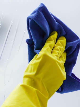 Person using cloth cleaning detergent to clean window glass. House clean products, household care equipment.の写真素材