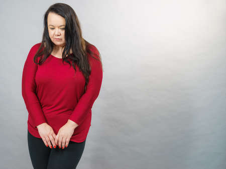 Bad and negative emotions and feelings concept. Unhappy sad fat woman. Depressed dissatisfied big adult female.の写真素材