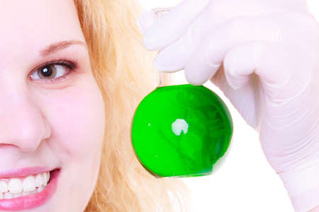 Science and education. Scientist at school laboratory. Happy girl holding chemical flask with green...