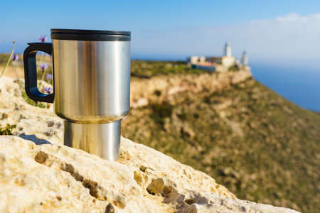 Thermal mug on nature. Travel destination, Mesa Roldan lighthouse in the background. Camping, vacation, lifestyle concept.の写真素材