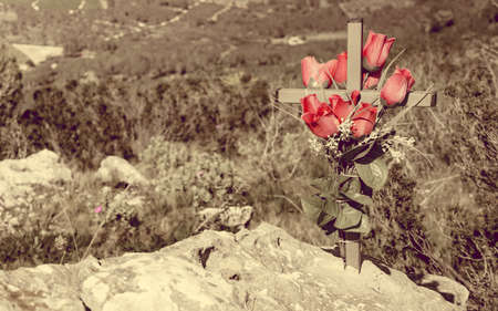 Memorial site with flower and cross in mountains, Spain. Marker that usually commemorates site where a person died.の写真素材