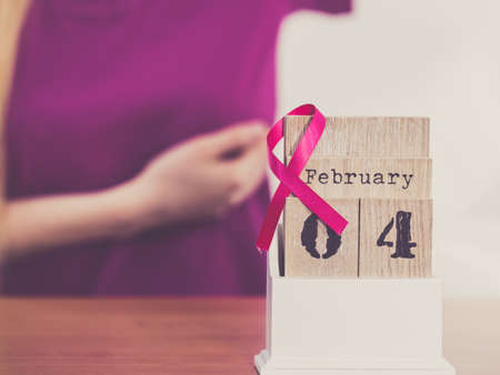 Woman and calendar, it is 4 february world breast cancer day, date with pink awareness ribbon. Healthcare and medicine concept.の写真素材