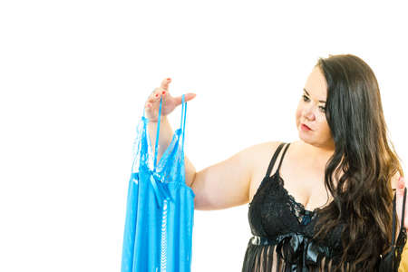 Woman choosing plus size sating chemise nightwear, sensual sleepwear for mature females.の写真素材