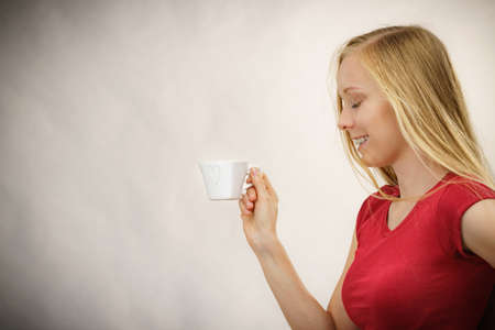 Blonde girl with heart shaped coffee cup. Copy space