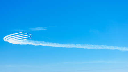 Airplanes on airshow. Aerobatic team performing flight at air show, drawing lines on blue sky.の写真素材