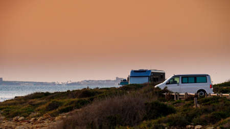 Camping on sea beach. Spanish Costa Blanca coastline with camper cars, Spain Alicante province.の写真素材