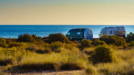 Camper, recreational vehicles on mediterranean coast in Spain. Camping on nature beach. Holidays and travel in motor home.の写真素材