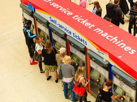 LONDON, ENGLAND - SEPTEMBER 20, 2014: People buying tickets using the self service ticket machine in Waterloo Railway Station, London.のeditorial素材