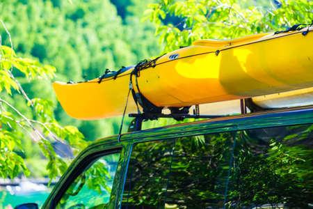 Active lifestyle sport concept. Car with two canoes on top roof in green norwegian mountains.の写真素材