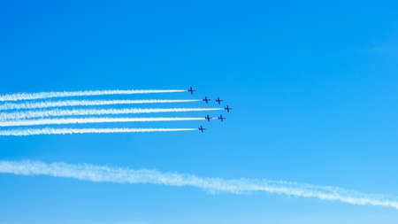 Airplanes on airshow. Aerobatic team performing flight at air show, drawing lines on blue sky.の写真素材