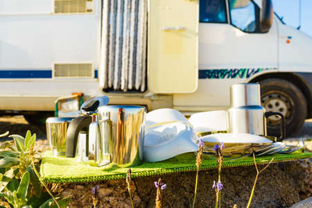 Many clean dishes outdoor on dish drying mat against camper vehicle. Washing up on fresh air. Camping on nature, dishwashing outside. Longing for an rv dishwasher.の写真素材