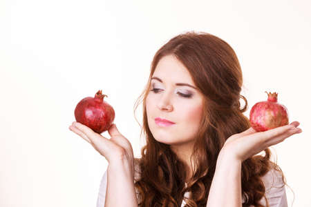 Woman brunette girl holding pomegranate fruits in hands, on white.の写真素材