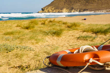 Rescue red lifebuoy, life preserver saver ring on beachの写真素材