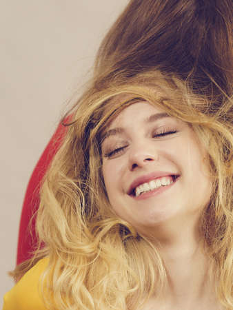 Woman playing with her female friend long ombre color hair. Different hairdo colors, haircare and...