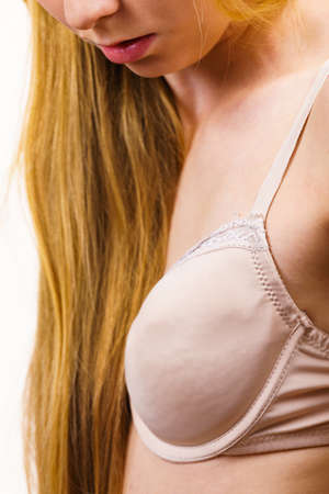 Young long hair blonde woman small boobs wearing wrong bra. Female breast in lingerie. Bosom, brafitting and underwear concept.の写真素材