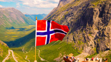 Trollstigen mountain road landscape in Norway, Europe. Norwegian flag waving and many tourists...