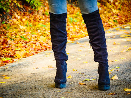 Woman wearing long black heeled knee high boots and jeans. Autumn fashion, warm footwear boots.の写真素材